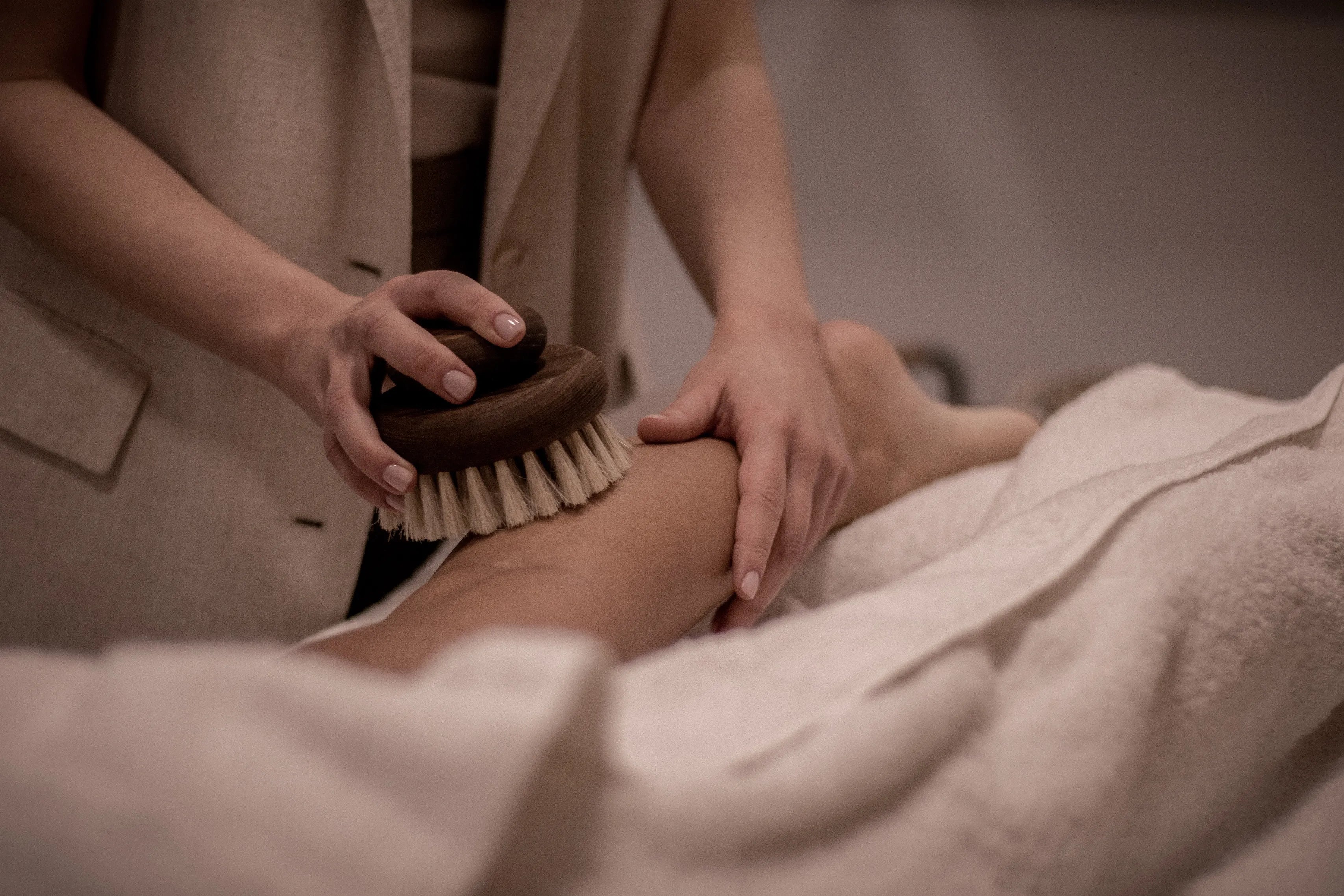Onar Wellness body ritual with a dry brush massage technique, designed to stimulate circulation and detoxify the skin.