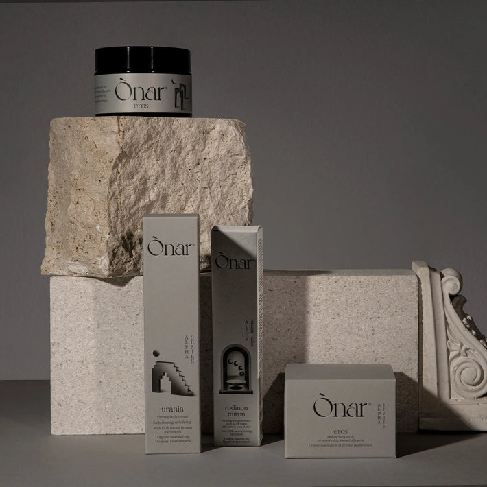 Onar skincare products on a neutral background with stone architecture.